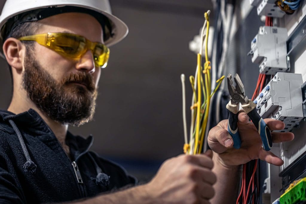 Electrical engineer working with switchboard and electrical connecting cable. find out what makes electrical engineering one of the high paying engineering jobs in the USA